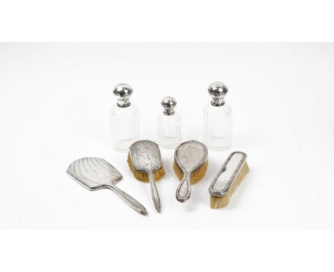 A group of silver mounted dressing table wares, comprising; a hand mirror, Birmingham 1935, a hairbrush in a matching design,