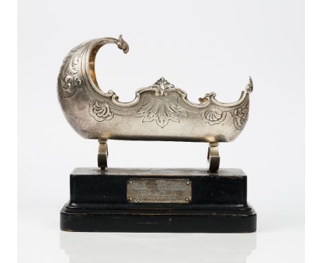 A Victorian silver model of a cradle, decorated with a scrolled rim and further embossed with scrolls, raised on two rockers,