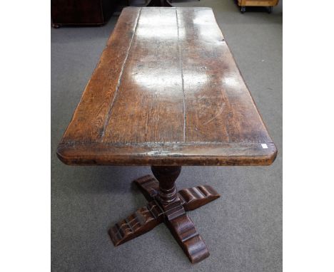 A Tudor style oak refectory table, the cleated planked rectangular top, on leaf and lunette carved inverted baluster turned l