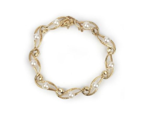 A gold and cultured pearl bracelet, in a pierced and engraved serpentine link design, mounted with cultured pearls at interva