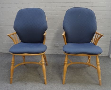 Ercol; a pair of ash and elm stick back Windsor chairs, on turned supports, united by crinoline stretcher, 55cm wide x 106cm 