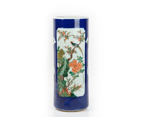 A Chinese porcelain blue-ground cylindrical stick stand, late 19th century, painted in famille-verte enamels with a large pan