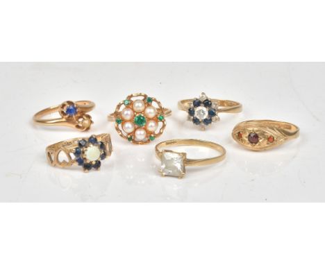 A 9ct gold and garnet set three stone ring, a 9ct gold, cultured pearl and green gem set cluster ring, a 9ct gold, opal and s