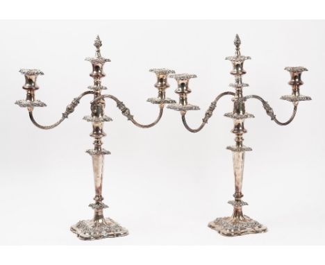 A pair of plated on copper three light table candelabra, with scrolling arms, central detachable flame finials, each raised o