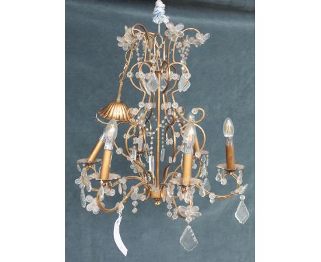 A 20th century gilt metal and glass six light chandelier, with scrolling branches and faceted drops, 90cm drop x 57cm wide.