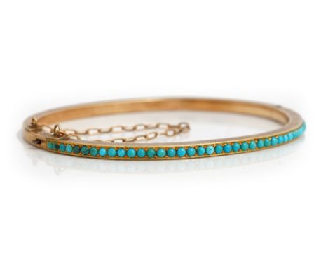 A gold and turquoise set oval hinged bangle, the front mounted with a row of circular turquoise on a snap clasp fitted with a