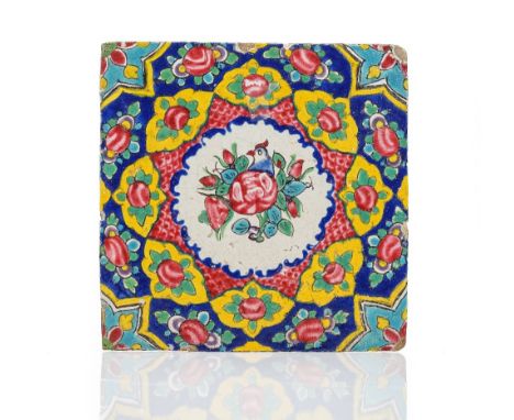A Persian pottery tile, Zand or Qajar, 18th/19th century, brightly painted in the centre with a bird amongst foliage inside f