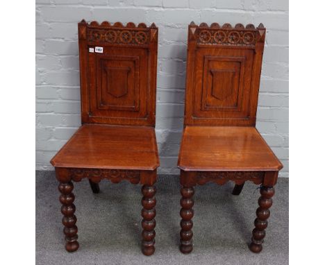 A pair of Victorian oak Gothic revival hall chairs, with vacant shield back on bobbin turned supports, 42cm wide x 88cm high,