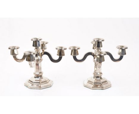 A pair of foreign silver five light table candelabra, with a central light surrounded by four scrolled single light arms, rai