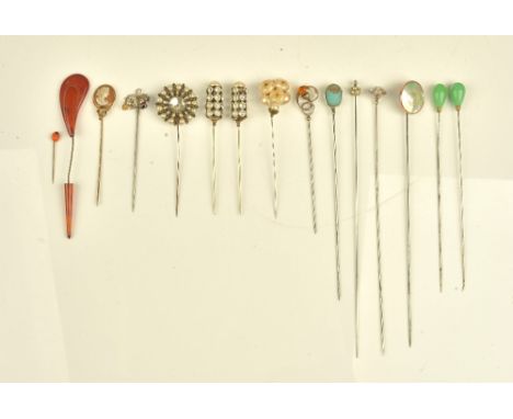 A collection of fifteen hat and stick pins including, a shell cameo, two thistles and two pairs of hat pins, one with pale gr