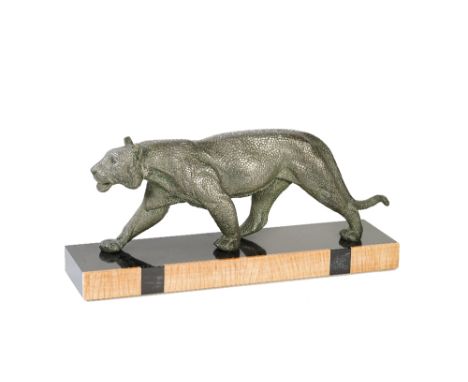An Art Deco patinated spelter sculpture of a lioness, mounted on a rectangular marble base, inscribed 'RULAS', 57cm wide.