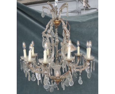 A 20th century glass ten-light chandelier, with scrolling branches and hung with faceted drops, 107cm drop x 73cm wide.