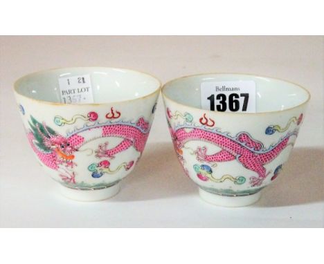 A pair of Chinese famille-rose wine cups, iron-red Qianlong seal marks but later, each enamelled with a pink-scaled dragon am