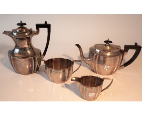 A silver four piece tea set, each piece of panelled oval form, the two larger pieces having black fittings, comprising; a hot