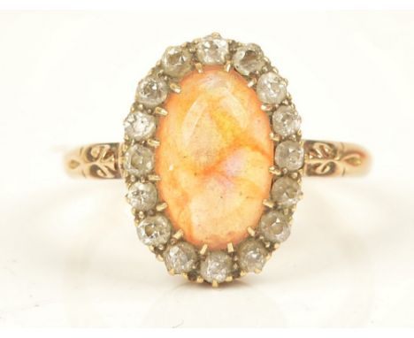 A gold, water opal and diamond set oval cluster ring, claw set with the oval water opal in a surround of cushion shaped diamo