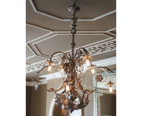 A silvered wrought metal six-light chandelier, of scrolling form applied with flower heads and leaf scrolls, 137cm high x 106