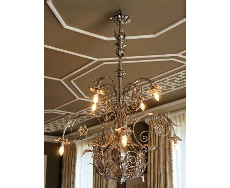 A silvered wrought metal six light chandelier, of scrolling form applied with flower heads and leaf scrolls, 137cm high x 106
