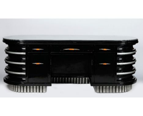 An Art Deco ebonised and silvered wood banded office desk, with rounded ends, fitted with three frieze drawers with cupboards