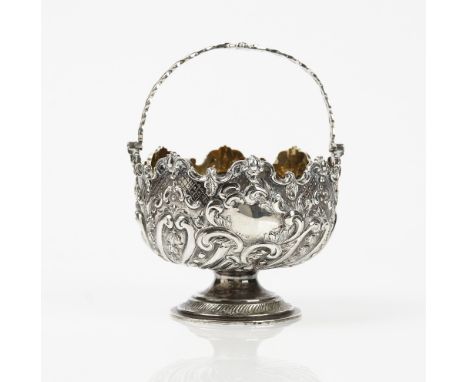 A late Victorian silver sugar basket, decorated with scroll fluting and foliate sprays within a shaped rim, fitted with a pie