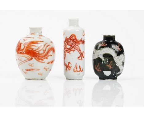 Three Chinese porcelain snuff bottles, late 19th/20th century, comprising; a cylindrical bottle, painted with an iron-red dra