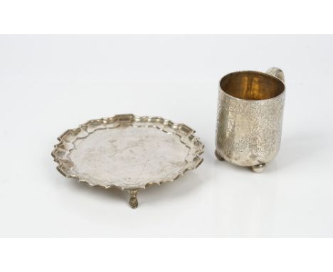 A silver card tray, of shaped circular form, having a piecrust rim in the Chippendale style, raised on three feet, diameter 1