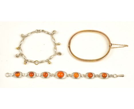 A gold oval hinged bangle, on a snap clasp, gross weight 10.2 gms, a reconstituted amber bracelet and a silver baton shaped l