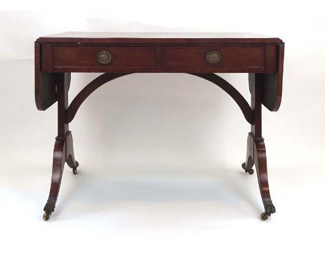 A 19th century mahogany and crossbanded sofa table with two frieze drawers over shaped supports, scrolled feet with brass cla