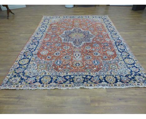 A Tabriz carpet, North West Persia, the madder field with an indigo arabesque medallion, scrolling foliate vines, indigo palm