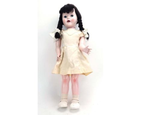 A mid-20th century Pedigree 'Walking Doll' wearing a pale yellow dress, h. 68 cm*with original instruction leaflet   CONDITIO