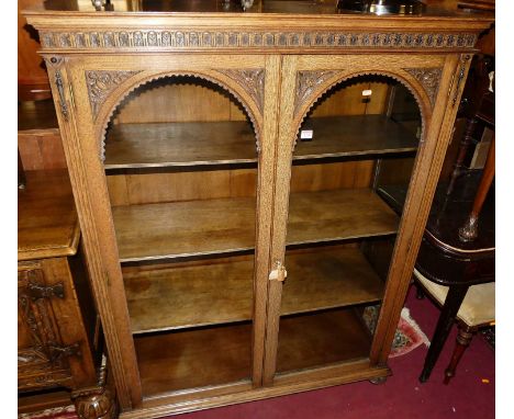 A circa 1900 relief carved oak arched double door glazed bookcase, on squat bun supports, w.111cmCondition report: Condition 