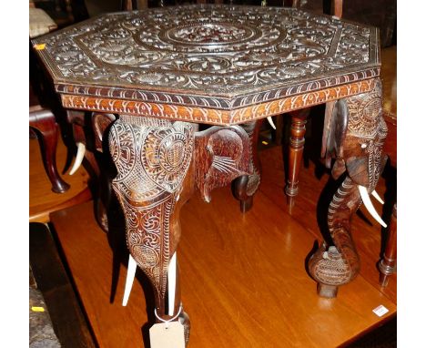 A circa 1900 Indian heavily relief carved teak octagonal occasional table, the top surface floral scroll decorated and raised