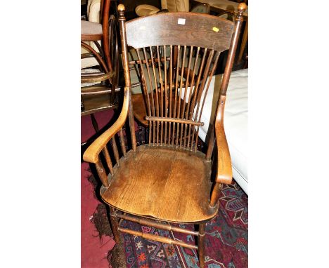 An early 20th century oak comb back armchair, raised on spindle turned stretchers, w.60cm 