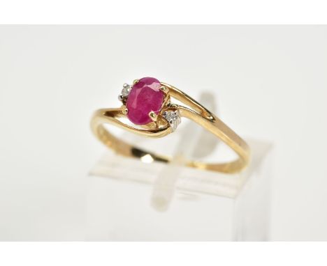 A 9CT GOLD RUBY AND DIAMOND RING, the openwork crossover design, with a central claw set oval cut ruby, flanked with round br