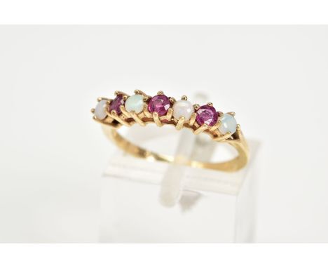 A 9CT GOLD RUBY AND OPAL RING, set with four cabochon opals, interspaced with three circular cut rubies, to the trifurcated s