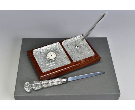 A BOXED WATERFORD CRYSTAL DESK SET, comprising a quartz clock and a pen stand with pen set in a wooden stand, together with a