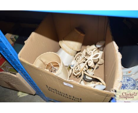 A box containing metal light fittings and shades