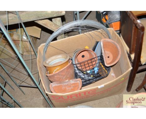 A box of various gardening tools and planters