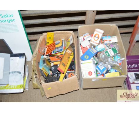 Two boxes and various tape measures, levels and light bulbs