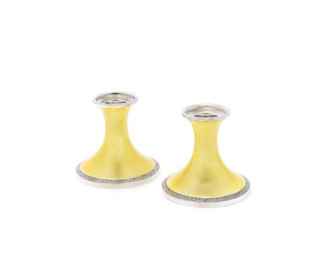 A pair of silver and enamel candlesticksHenry Matthews, Birmingham 1928 Flaring form, with yellow enamel over an engine-turne