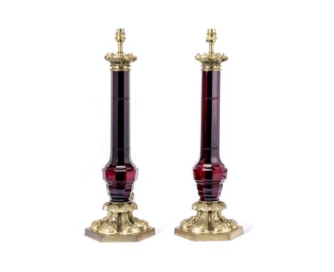 A pair of brass mounted ruby glass lamp basesin the Victorian stylethe canted column and baluster shafts with foliate collars