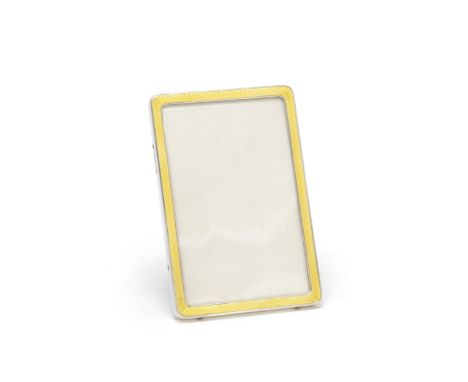 A silver and enamel photograph frameFinnigans Ltd, London 1919 The yellow enamel over an engine-turned ground, the easel back
