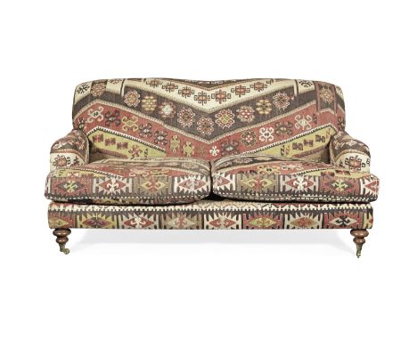 A kilim upholstered stained beech sofaon baluster turned front legs terminating in brass cappings and castors, with splayed s