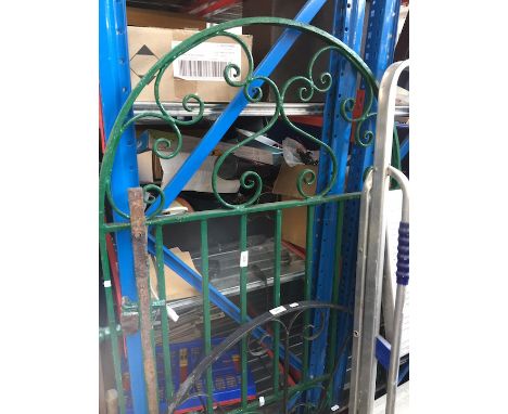 A green painted wrought iron gate. 