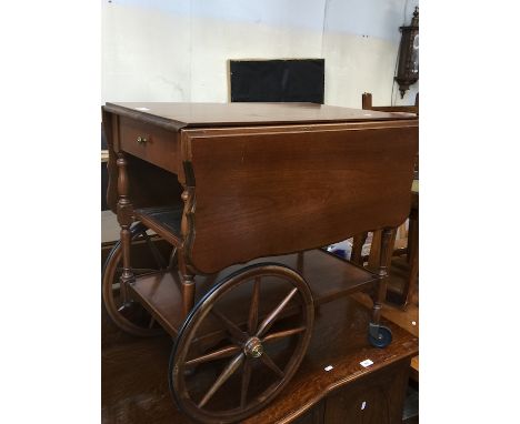 A mahogany drop leaf tea trolley with glass top slide shelf 