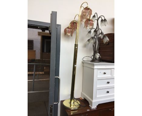 A brass standard lamp with glass shades. 