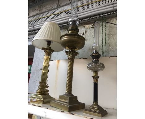 Two oil lamps and a brass corinthean column table lamp 