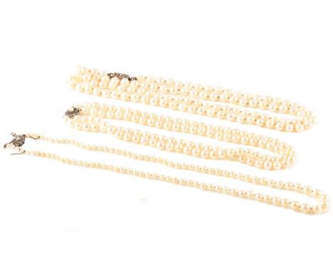 A group of three pearl necklaces, including a double row pearl choker with silver clasp, a long single row pearl necklace wit