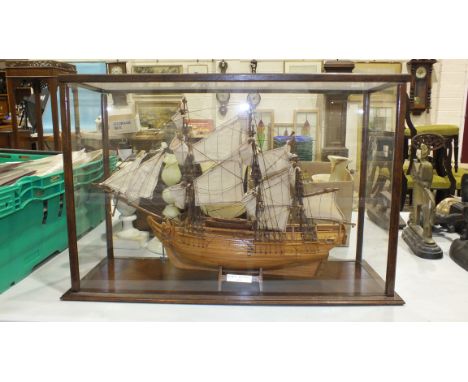 A modern model of HMS Bounty in wood and Perspex case, a small table-top shutter-front stationery cabinet, an alabaster table