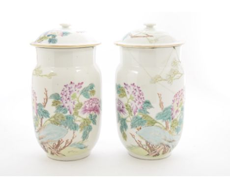 A pair of Chinese porcelain jars and covers, each with enamel floral decoration, character marks to covers, bodies and bases,