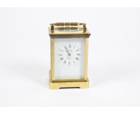 A 20th Century French brass carriage clock, of cartouche form, white enamel dial with Roman numerals, the dial and movement s